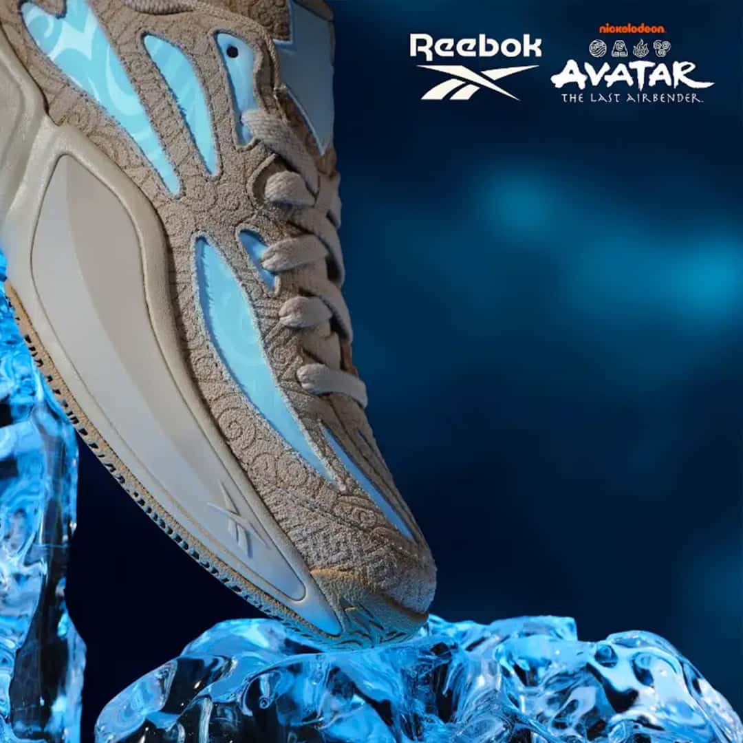 Reebok Engine A 26 Avatar en beige con paneles celestes y dibujos de remolinos, apoyada sobre un bloque de hielo iluminado en azul, con los logos de Reebok y Avatar: The Last Airbender