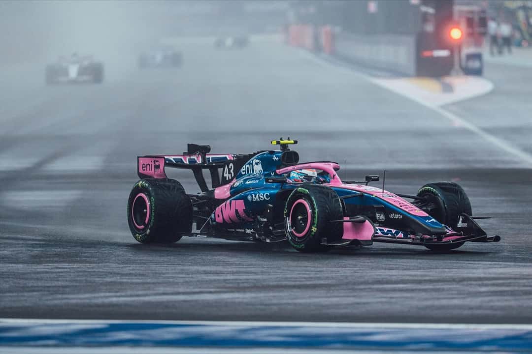 El Alpine número 43 de Franco Colapinto avanza sobre la pista mojada de Marina Bay, entre el rocío y la neblina, con otros autos al fondo