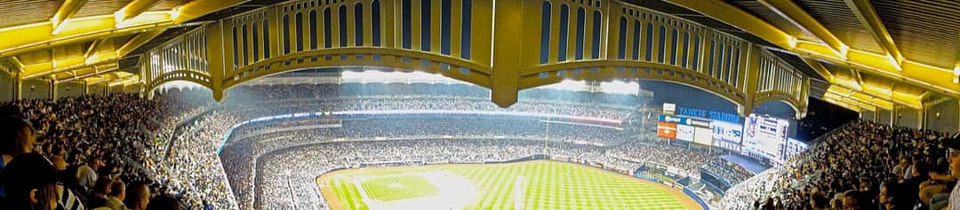 Foto de archivo: vista panorámica de Yankee Stadium de noche, con las tribunas llenas y el friso del techo iluminado