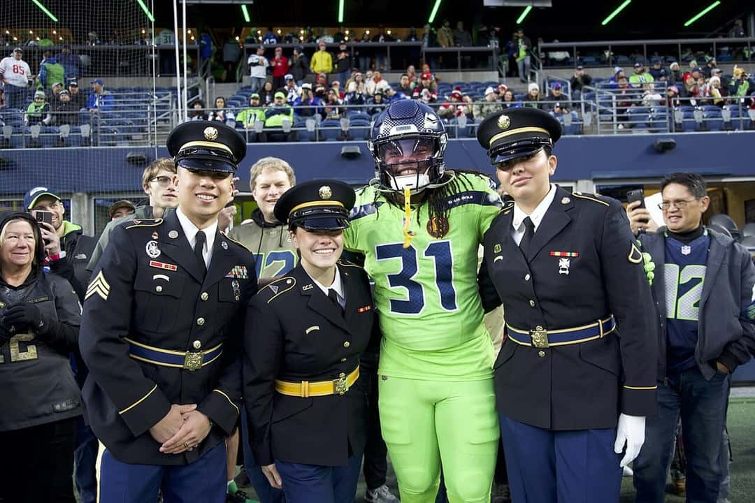 Foto de archivo: un jugador de los Seattle Seahawks con la camiseta verde fluorescente número 31 posa con integrantes de la Guardia Nacional en el campo del Lumen Field antes de un partido