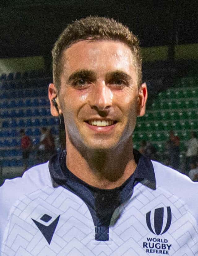 Foto de archivo: Damián Schneider sonríe con la camiseta blanca de árbitro de World Rugby y un auricular en la oreja