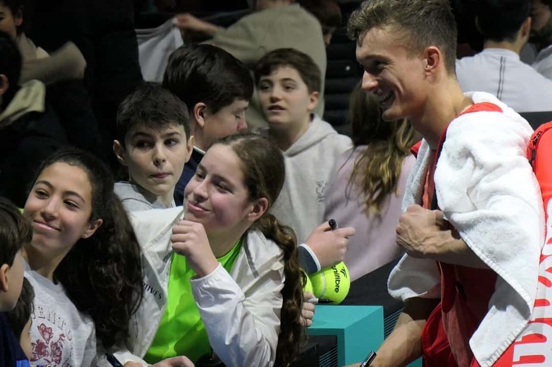 Foto de archivo: Jiri Lehecka, con toalla blanca al hombro, firma autógrafos y sonríe junto a chicos en la tribuna