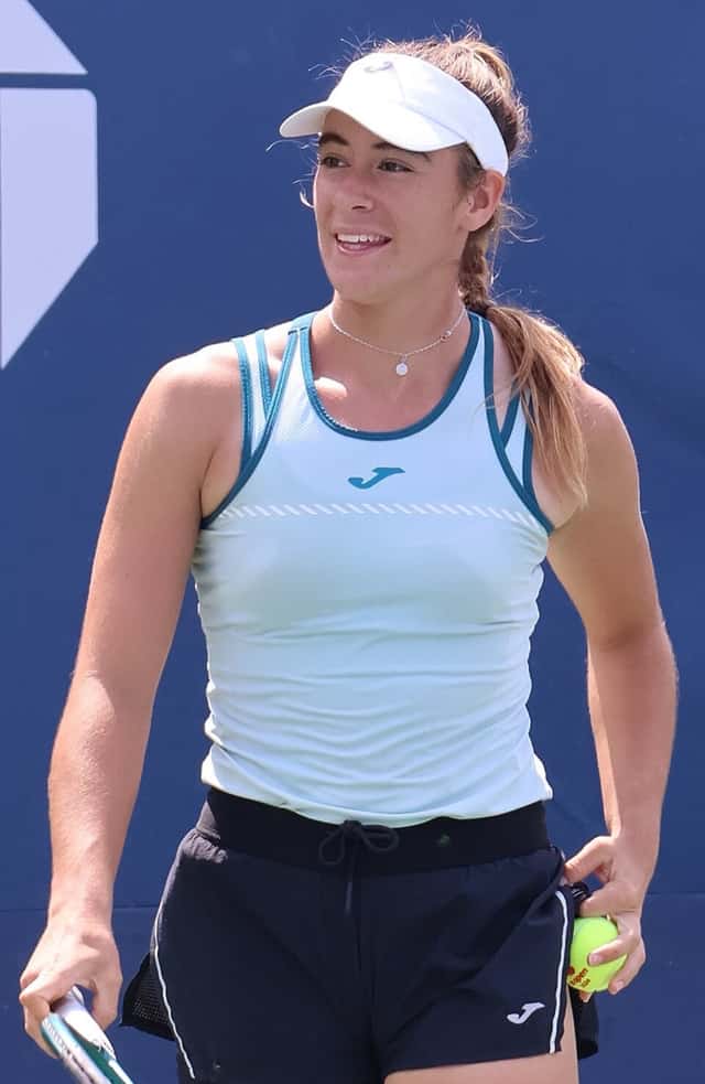 Foto de archivo: Solana Sierra, con visera blanca y musculosa celeste, sonríe en una cancha del US Open 2024