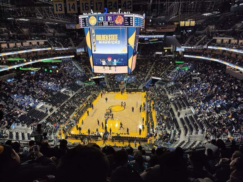 Foto de archivo: vista desde lo alto del Chase Center de San Francisco durante un partido de los Golden State Warriors, con la cancha de madera, la pantalla gigante en el centro y las tribunas llenas