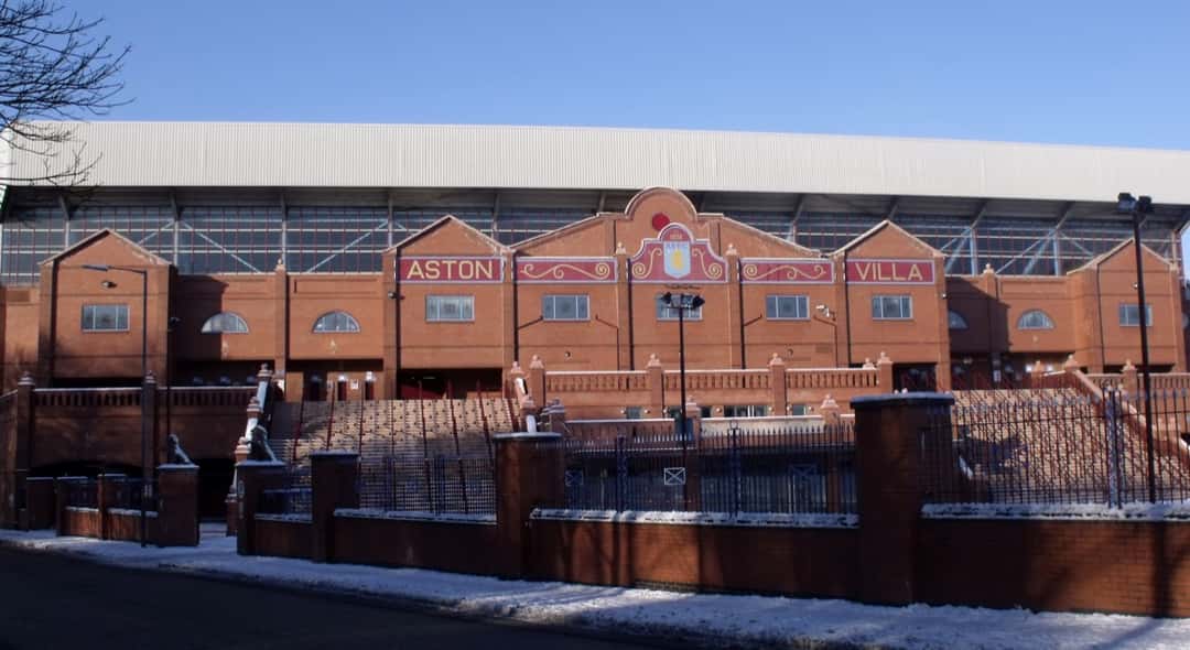 La fachada de ladrillo de la tribuna Holte End de Villa Park, con el escudo y el nombre del Aston Villa; foto de archivo de enero de 2010 (foto: Elliott Brown, retocada por Blackcat, Wikimedia Commons, licencia CC BY 2.0)