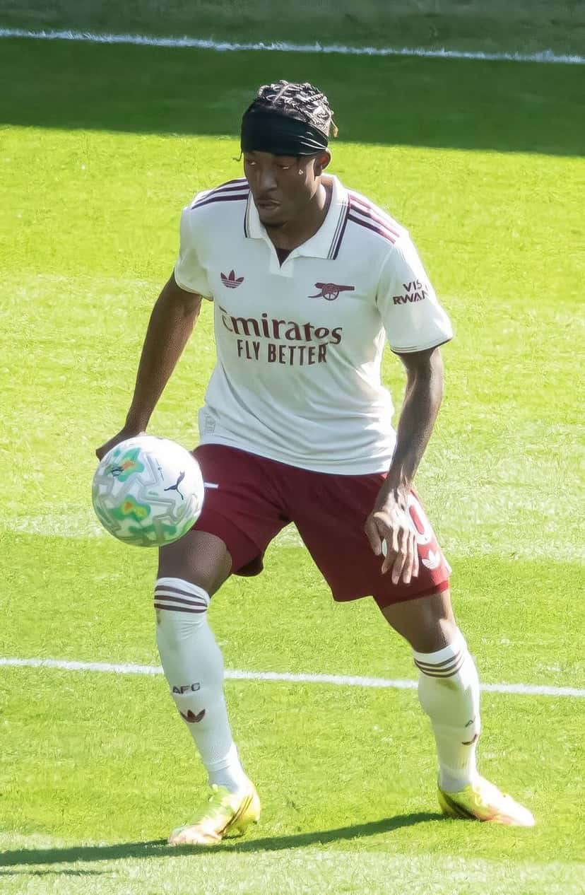 Noni Madueke, con la camiseta blanca y el short bordó del Arsenal, controla la pelota con la mano sobre el muslo durante un partido de la Premier League; foto de archivo de mayo de 2026 (foto: Chensiyuan, Wikimedia Commons, licencia CC BY-SA 4.0)