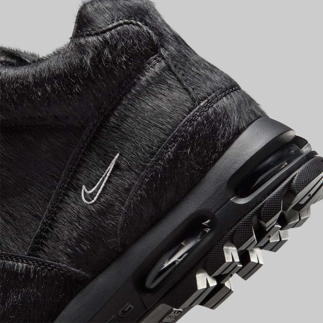 Detalle del lateral de la Nike Air Max Goadome Black Pony Hair, con el pelo negro, el Swoosh blanco bordado y la cámara de aire en la entresuela