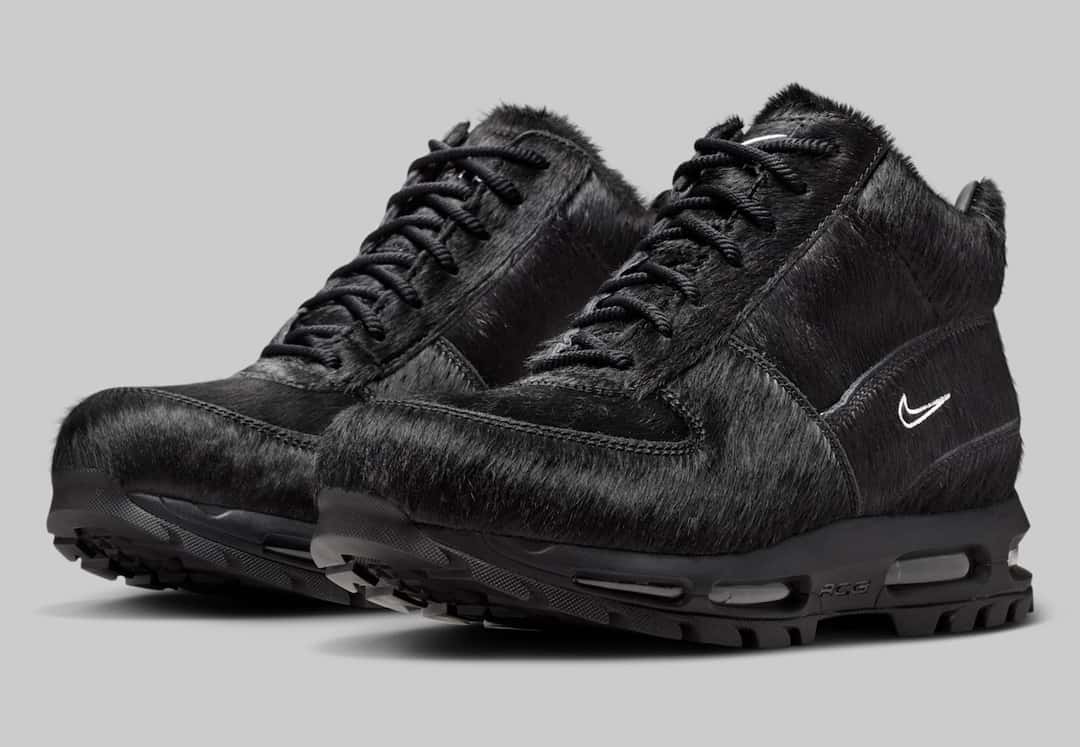 Par de Nike Air Max Goadome Black Pony Hair en tres cuartos sobre fondo gris, con el pelo negro en toda la capellada, cordones negros y Swoosh blancos