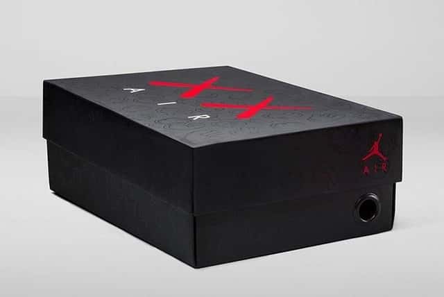 Foto de archivo: caja negra del KAWS x Air Jordan 4 de 2017, con el logo XX en rojo, la palabra AIR en blanco, las manos de KAWS grabadas en relieve y el Jumpman rojo en el costado