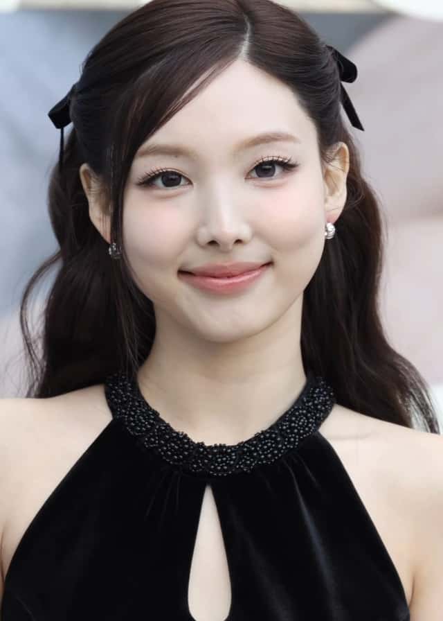 Nayeon de TWICE sonriendo en noviembre de 2025, con el pelo largo oscuro atado con moños negros y un vestido negro de cuello alto (foto de archivo). Foto: TV10, CC BY 3.0, vía Wikimedia Commons