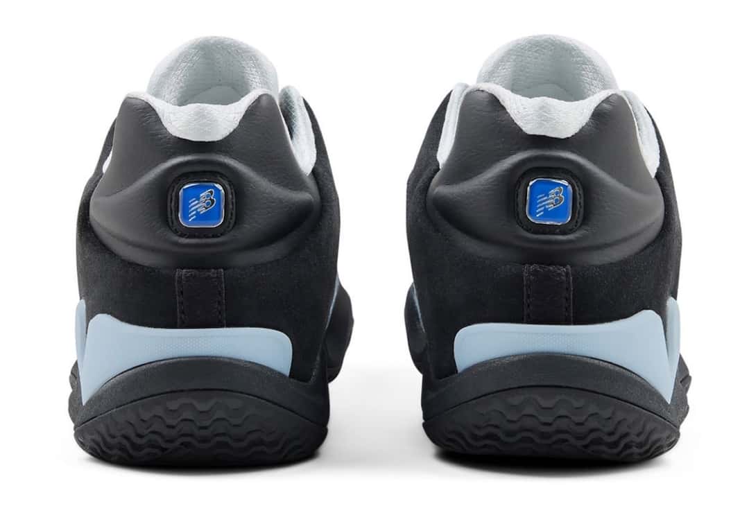Talón de las New Balance Maxey V1 con la insignia Flying NB azul y los refuerzos celestes en la base