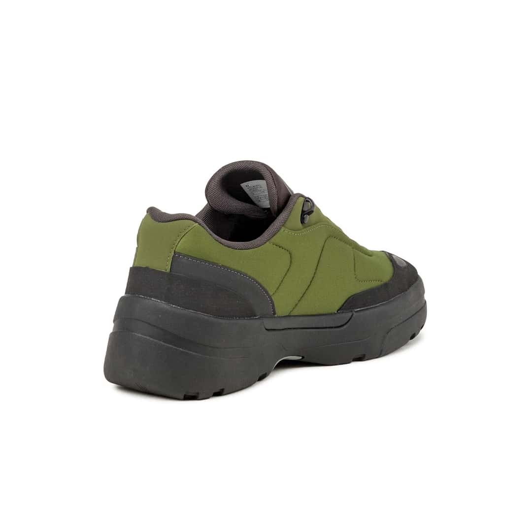 Talón del New Balance TL900 Sport Green/Black, con el refuerzo negro que envuelve la parte trasera, el cuello acolchado gris y la suela de goma negra con tacos