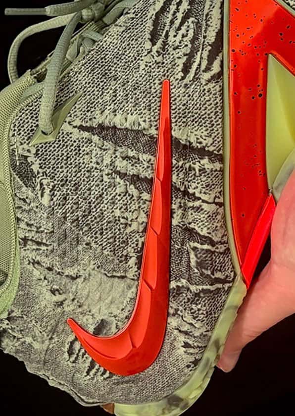 Lateral del Nike Ja 4 Halloween con upper verde gastado tipo zombi y Swoosh moldeado rojo anaranjado