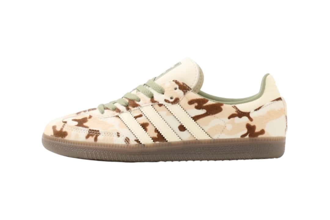 adidas Samba Camo Cow Print de perfil lateral sobre fondo blanco, con el upper de pelo en manchas de camuflado marrón y beige, las tres tiras dentadas de cuero crema, cordones verde salvia, el talón crema y la suela gum oscura