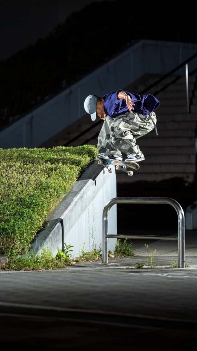 Ryuhei Kitazume salta para un frontside crooked grind sobre un borde de cemento con un cantero, de noche