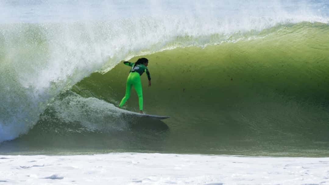Teresa Bonvalot, con lycra y calza verdes, se mete en el tubo de una ola verde en Supertubos