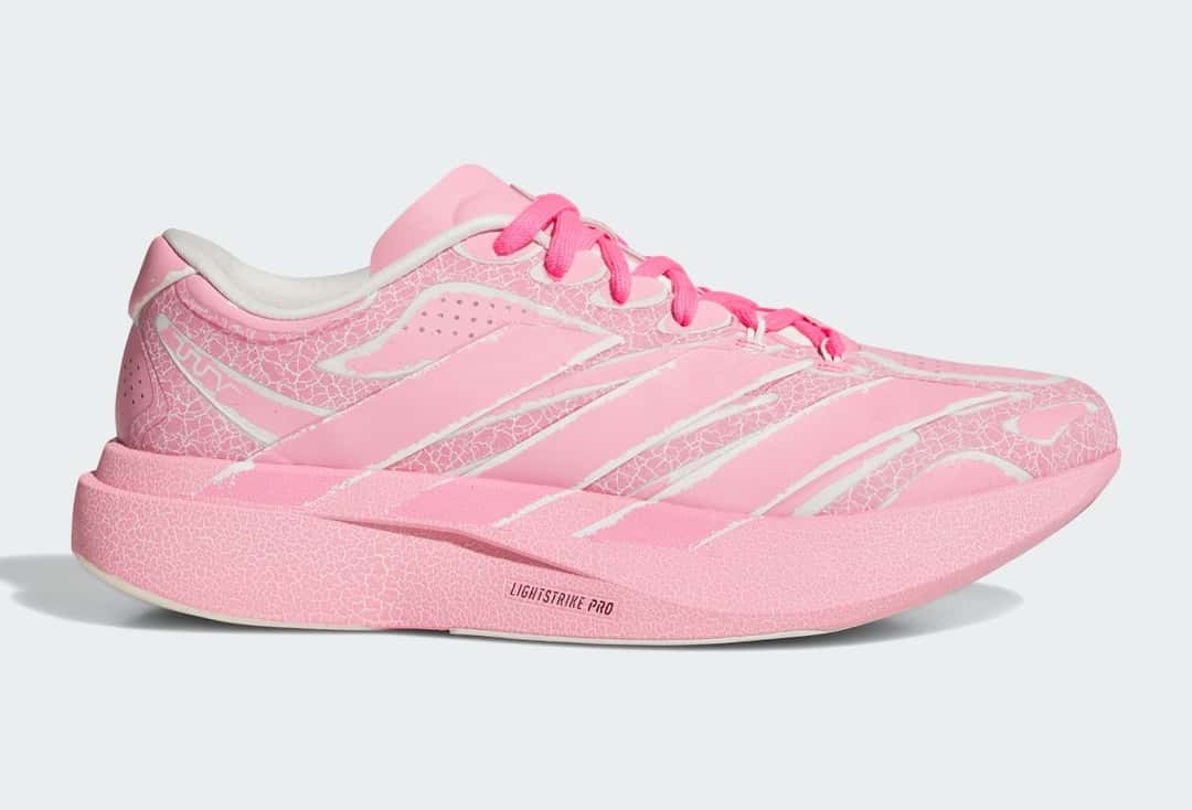 Adidas Adizero Evo SL Exo de The Whitaker Group en rosa, de perfil sobre fondo gris claro, con estampado agrietado en el upper y la mediasuela, cordones fucsia y la leyenda Lightstrike Pro en la mediasuela