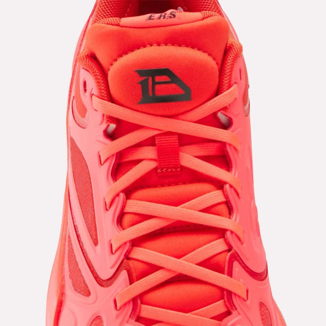 Primer plano de la lengüeta de la Reebok Engine A de Darius Acuff Jr., roja con el logo DA en negro y la inscripción ERS