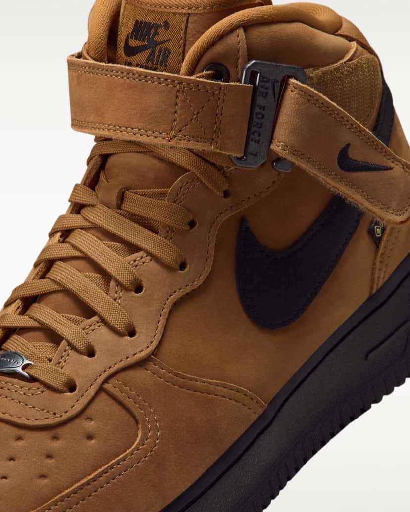 Detalle de la tira de la Nike Air Force 1 Mid GORE-TEX Vibram con la hebilla metálica negra y el Swoosh negro sobre el cuero color trigo