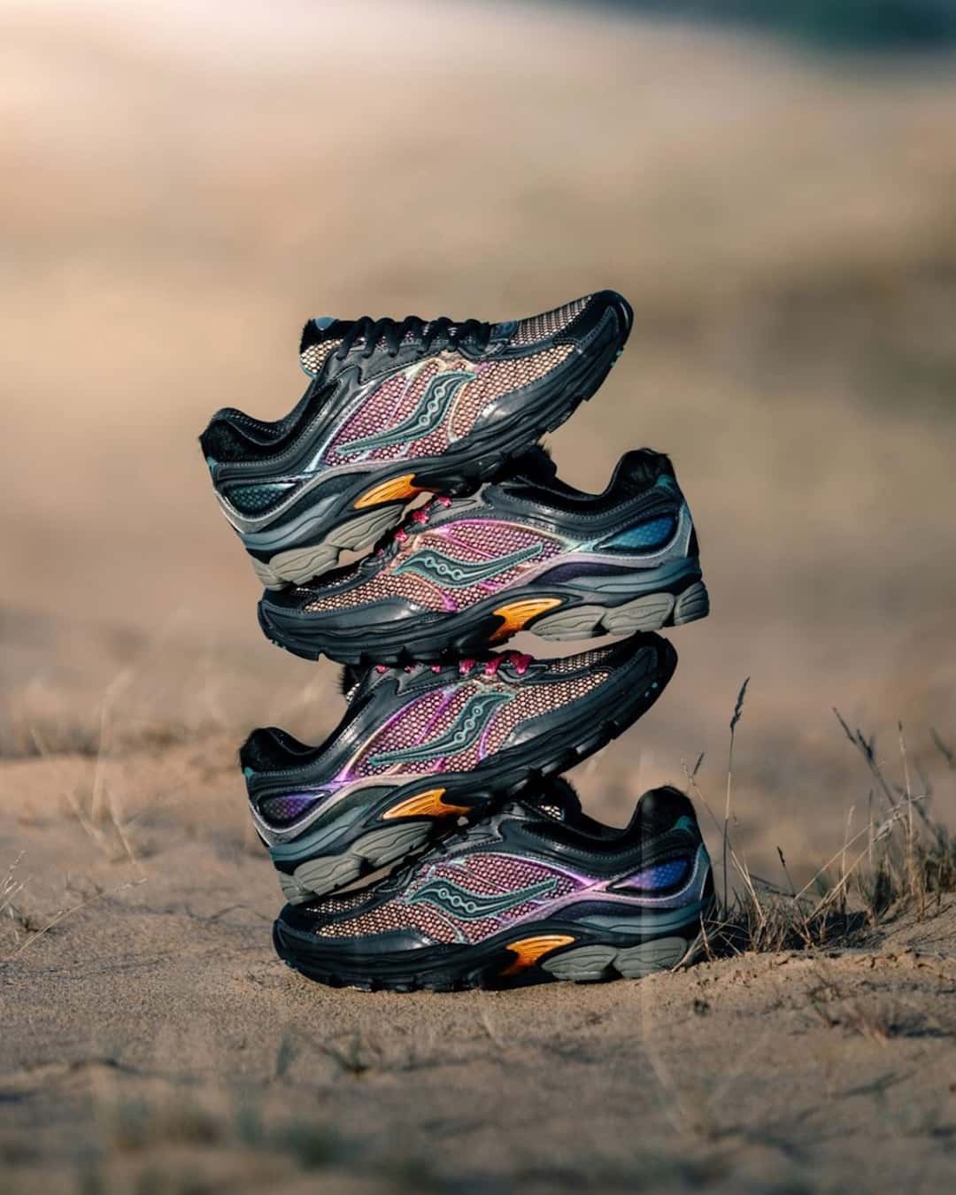 Cuatro pares de afew x Saucony ProGrid Omni 9 Tara Hawk apilados sobre la arena, con paneles plateados y malla violeta