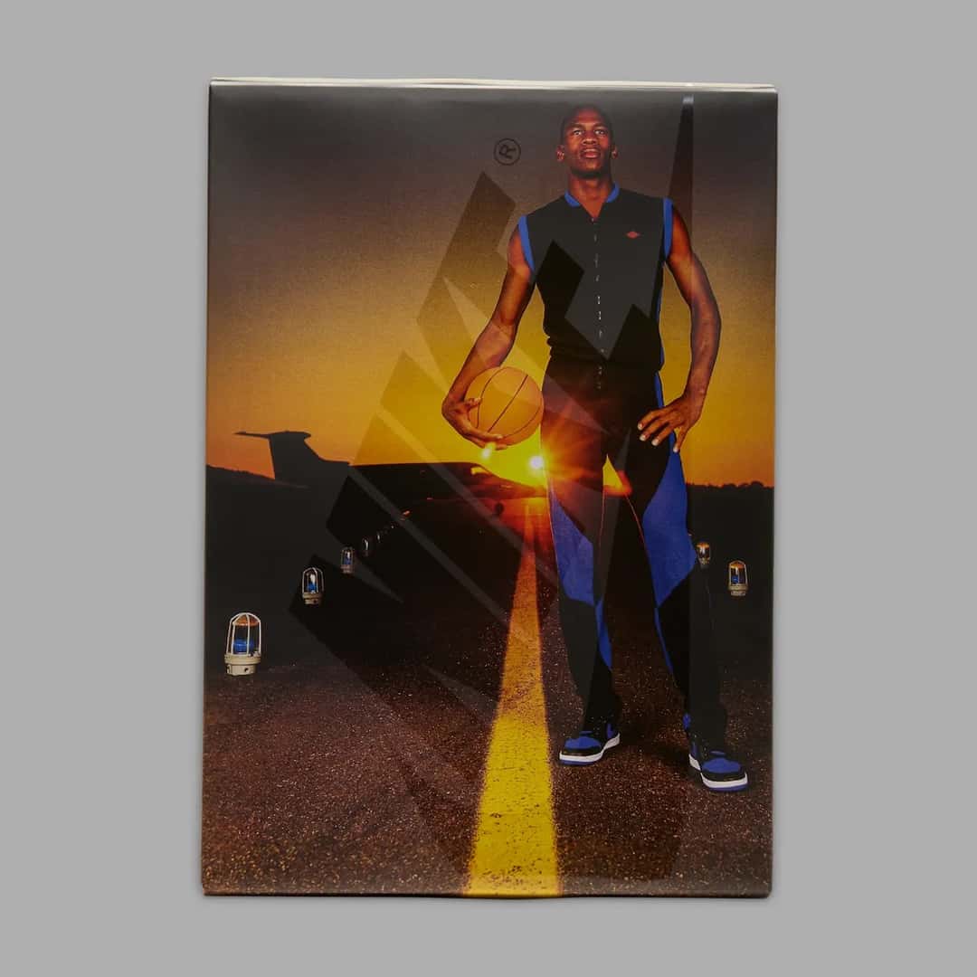 Caja especial del Air Jordan 1 Royal 2026 con la foto de Michael Jordan con pelota en la mano y conjunto negro y azul al atardecer