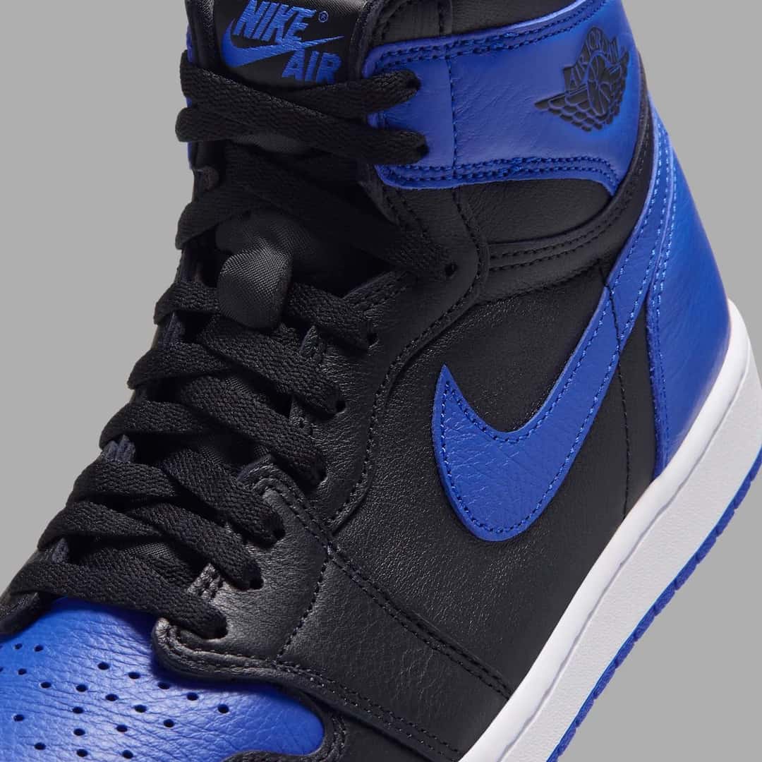 Detalle lateral del Air Jordan 1 High OG Royal 2026 con el Swoosh azul, el logo Wings en el cuello y la etiqueta Nike Air en la lengüeta