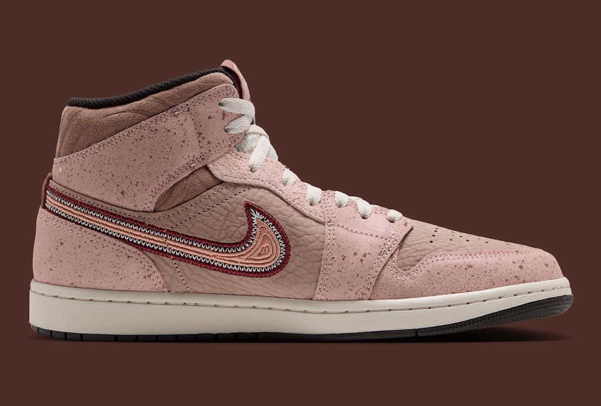 Air Jordan 1 Mid Día de Muertos de perfil, en rosa y marrón con puntitos, Swoosh bordado y suela crema, sobre fondo marrón