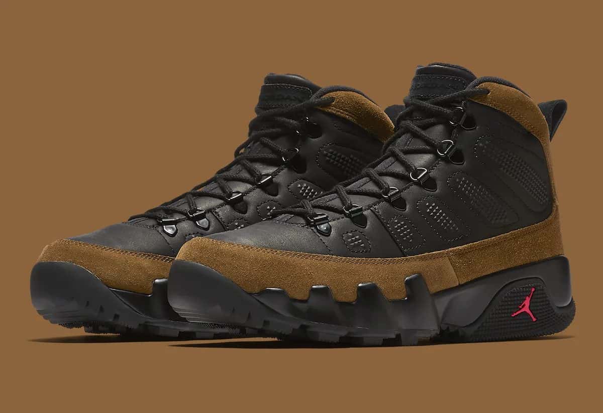 Par de Air Jordan 9 Boot Olive sobre fondo marrón, con cuero negro, gamuza verde oliva en la parte baja, ojales de metal negros y el Jumpman rojo en la suela