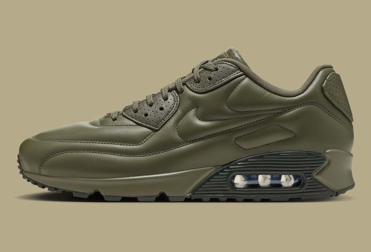 Nike Air Max 90 SP Medium Olive en cuero verde oliva, de perfil con la cámara de aire a la vista sobre fondo beige
