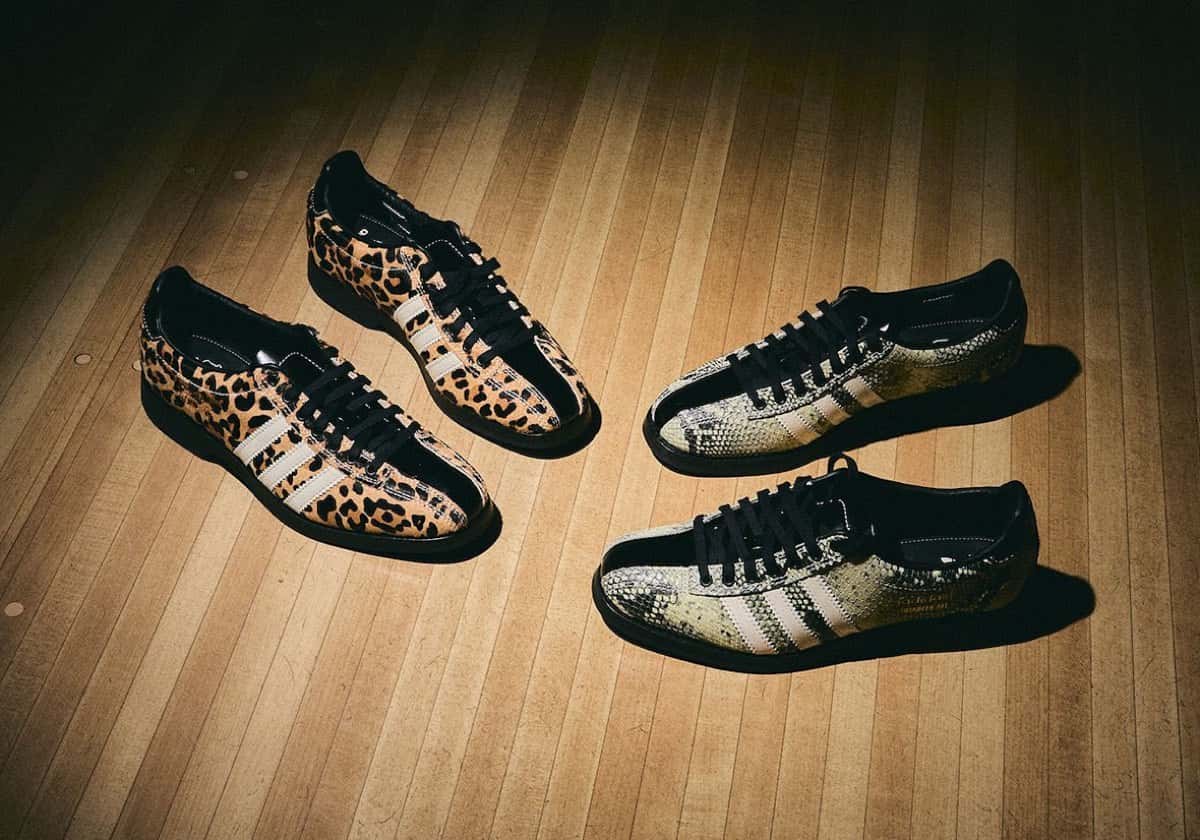 Dos pares del Brain Dead x adidas Samba Bowling sobre el piso de madera de una pista de bowling: a la izquierda el Cheetah con pelo estampado de guepardo y a la derecha el Snakeskin con textura de serpiente, ambos con tiras crema, puntera de charol negro y cordones negros