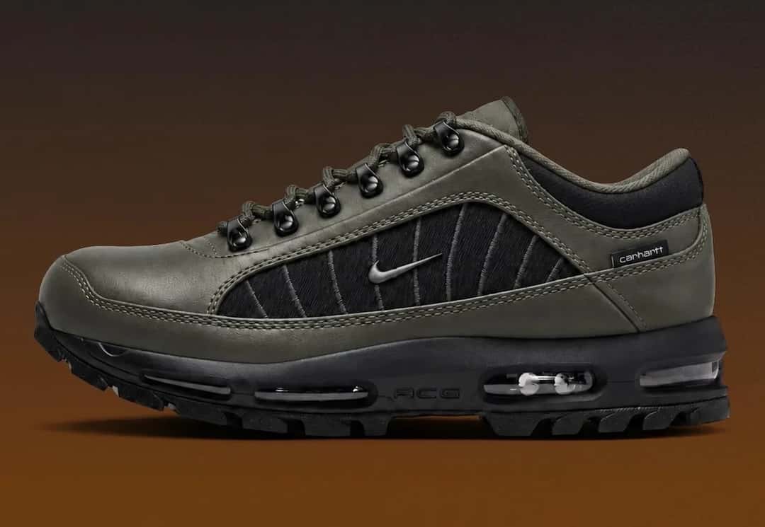 Nike Air Max Goadome Low de Carhartt WIP en verde oliva oscuro de perfil sobre fondo marrón, con panel lateral negro con costuras, Swoosh metálico, argollas de metal y suela negra dentada