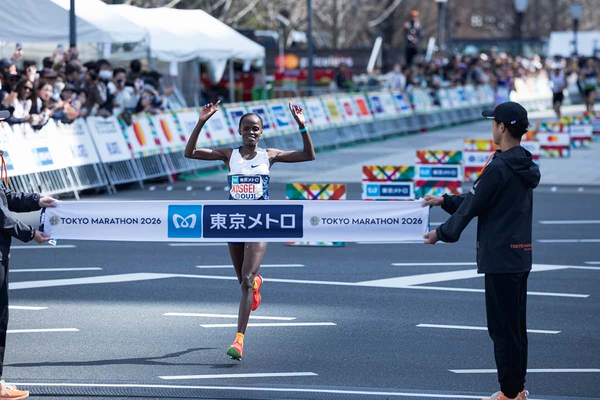 Foto de archivo: Brigid Kosgei, con musculosa blanca y zapatillas naranjas, levanta los brazos al cortar la cinta de llegada del Maratón de Tokio 2026