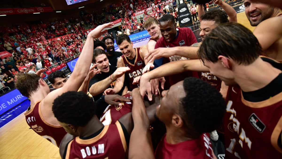 Los jugadores del UCAM Murcia, con camisetas bordó, festejan en ronda sobre el parquet del Palacio de Deportes tras ganarle al Barça