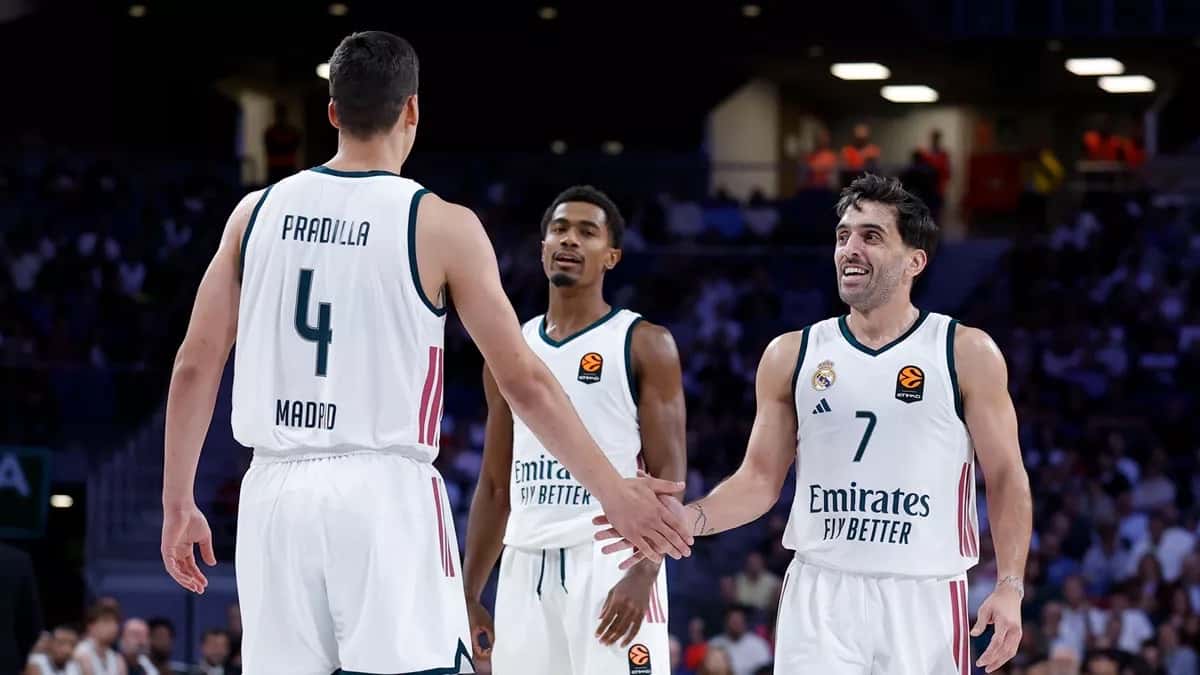 Facundo Campazzo, con la camiseta blanca número 7 del Real Madrid, sonríe y choca la mano de Jaime Pradilla durante el partido ante el Partizan en el Movistar Arena