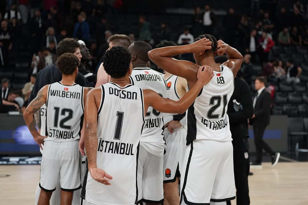Foto de archivo: jugadores del Beşiktaş, de blanco, de espaldas en la cancha durante un partido de Euroliga