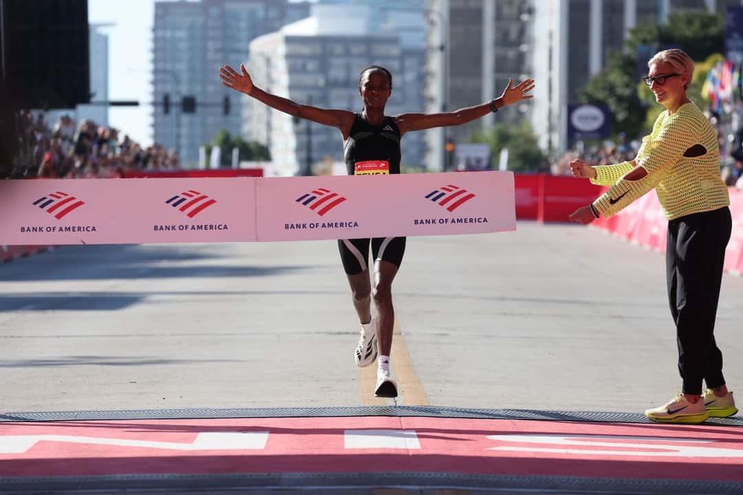 Hawi Feysa abre los brazos al cortar la cinta de llegada del Maratón de Chicago 2026, con musculosa negra y zapatillas blancas