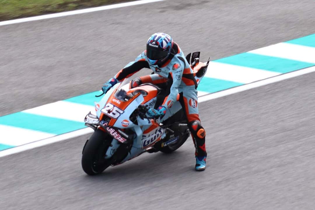 Foto de archivo: Raúl Fernández, con buzo celeste y naranja, inclina la Aprilia número 25 del equipo Trackhouse en una curva con pianos celestes y blancos