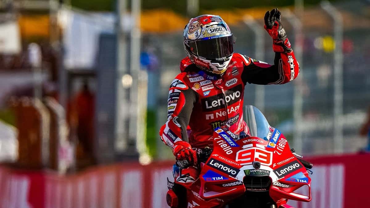 Marc Márquez saluda con la mano izquierda arriba de su Ducati roja número 93 en el circuito de Motegi