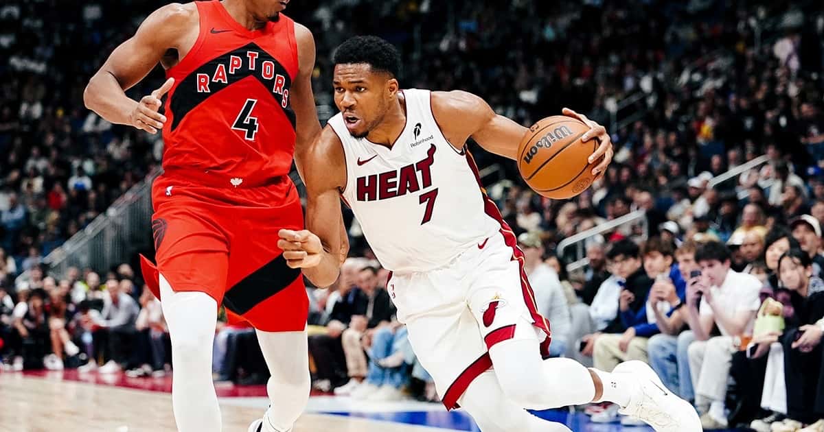 Giannis Antetokounmpo, con la camiseta blanca número 7 del Miami Heat, encara con la pelota ante Scottie Barnes, de los Toronto Raptors