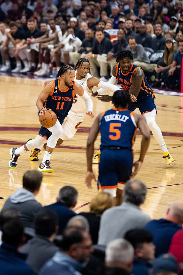 Foto de archivo: Jalen Brunson, de los Knicks, con la camiseta azul número 11, ataca el aro con la pelota entre defensores de Cleveland