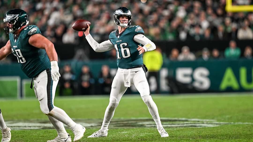 Tanner McKee, de los Eagles, con la camiseta verde número 16, prepara un pase en el Lincoln Financial Field