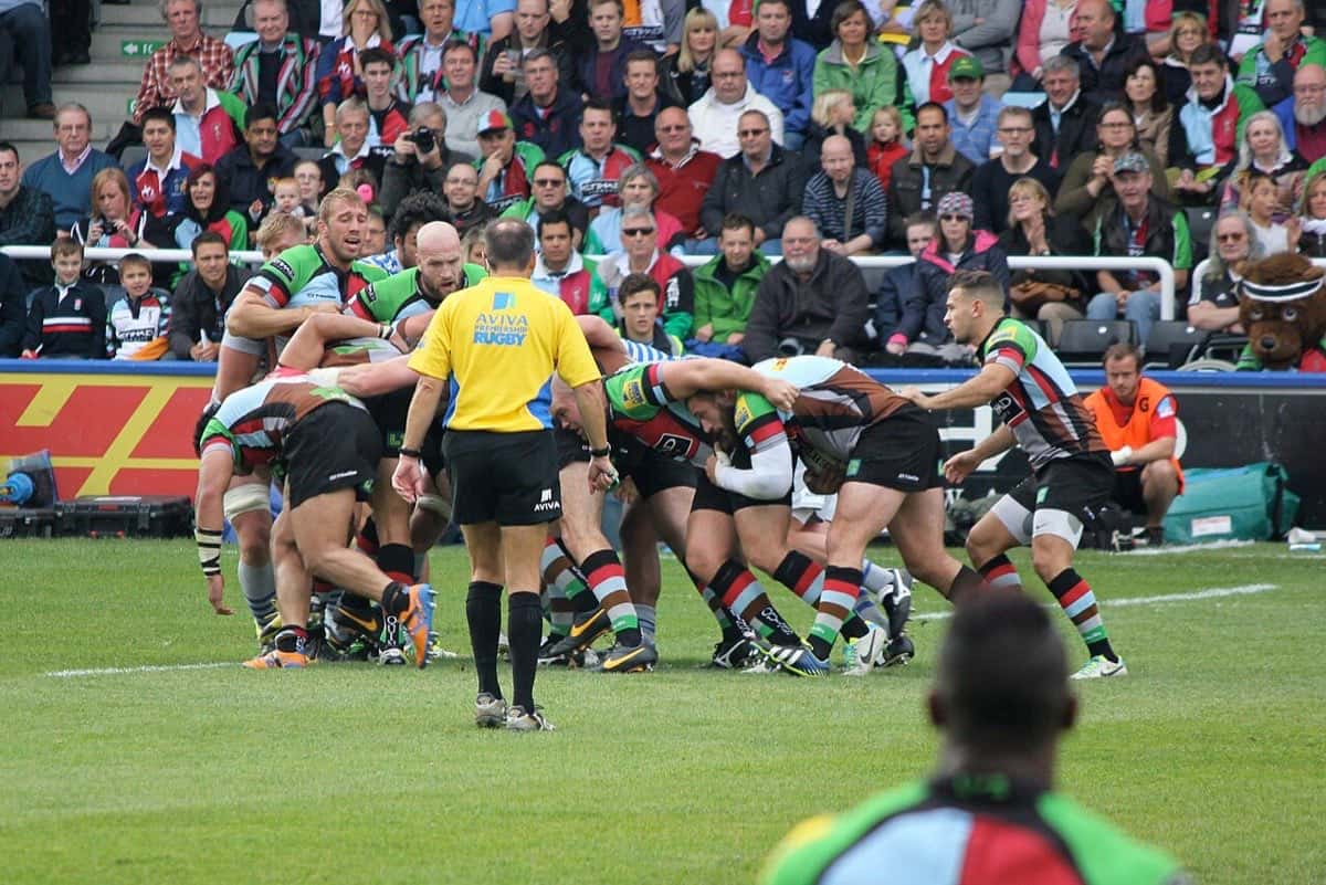 Foto de archivo: jugadores de Harlequins y Saracens pelean la pelota en un agrupamiento en un partido de 2013, con el árbitro de amarillo al costado y la tribuna llena detrás