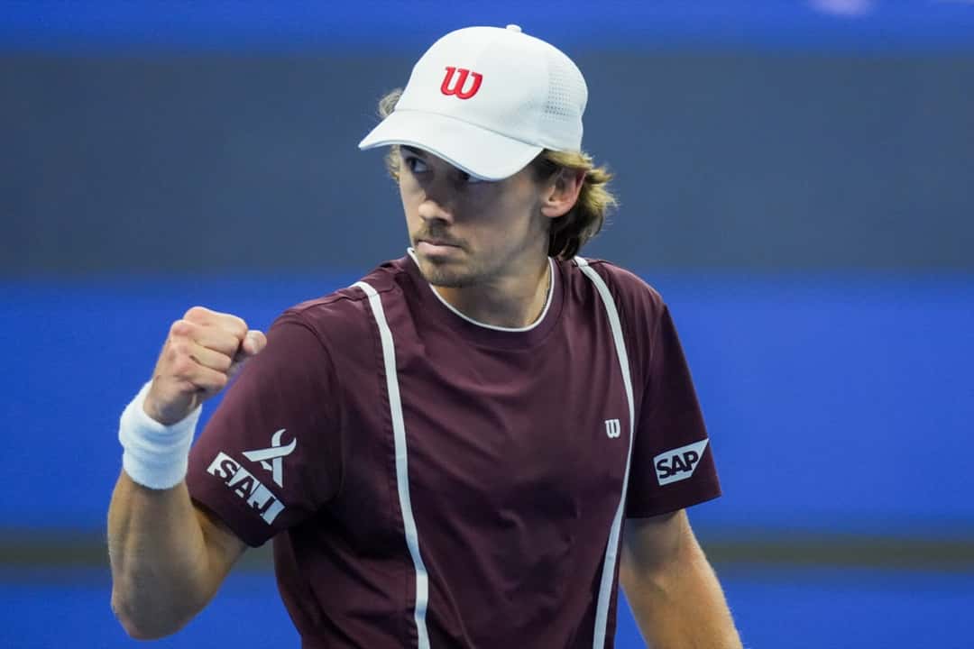 Alex de Minaur, con gorra blanca y remera bordó, aprieta el puño para festejar un punto en su semifinal del China Open 2026