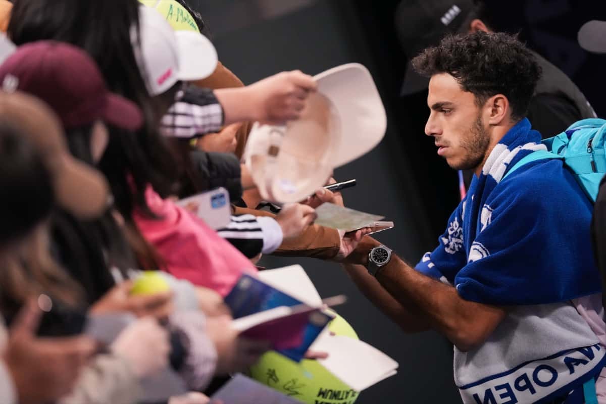 Francisco Cerúndolo, con una toalla del China Open sobre los hombros, firma autógrafos a los fanáticos en Beijing