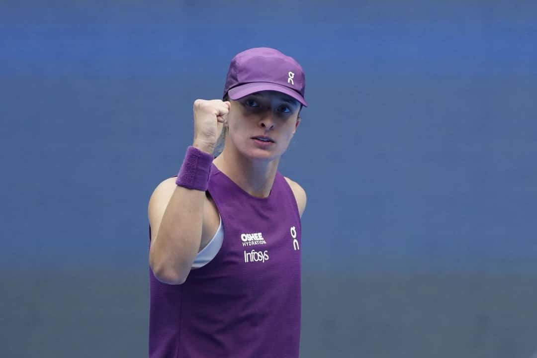 Iga Swiatek, con gorra y musculosa violeta, aprieta el puño durante su partido en el China Open 2026