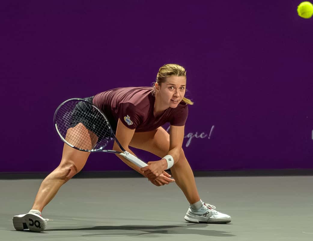 Foto de archivo: Maja Chwalinska, con remera bordó, se estira con la raqueta para devolver una pelota baja en el Transylvania Open 2026