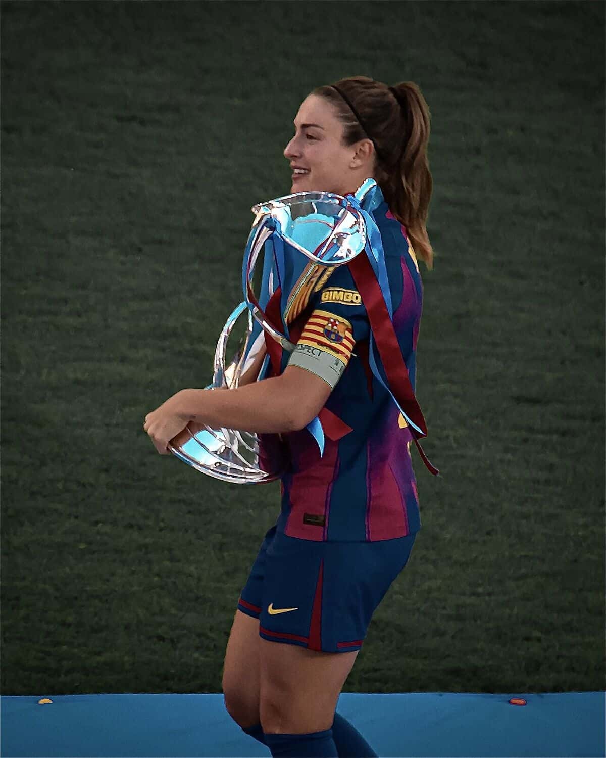 Alexia Putellas, con la camiseta del Barcelona y la cinta de capitana, lleva el trofeo de la Champions femenina en la final de 2026; foto de archivo del 23 de mayo de 2026 (foto: MichaelEmilio, Wikimedia Commons, licencia CC BY 4.0)