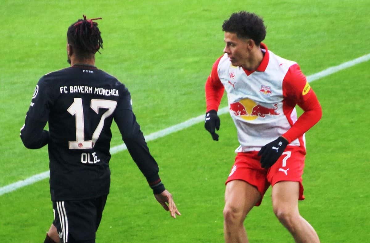 Michael Olise, de espaldas, con la camiseta negra número 17 del FC Bayern München, frente a un jugador del Salzburgo en un amistoso; foto de archivo de enero de 2026 (foto: Werner100359, Wikimedia Commons, licencia CC BY-SA 4.0)