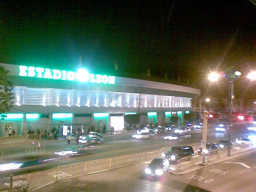 El estadio León de noche, con el cartel iluminado sobre la fachada y los autos pasando por la avenida; foto de archivo de 2009 (foto: Luz leo28, Wikimedia Commons, licencia CC BY-SA 4.0)