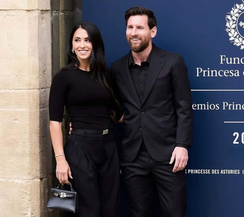 Lionel Messi y Antonela Roccuzzo, los dos vestidos de negro, posan delante del panel de los Premios Princesa de Asturias 2026 en Oviedo (foto: prensa oficial de la AFA)
